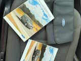 a car seat with two books on it and a bag in the back