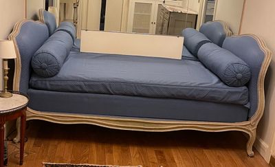 a blue couch in a living room with a mirror on the wall