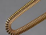 gold plated necklace with a long chain and a clasp on a table