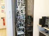une image représentant un serveur dans une pièce où se trouvent de nombreux câbles