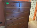 une commode marron dans un coin de la pièce