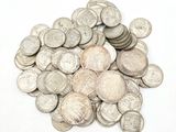 une pile de pièces d'argent posée sur une surface blanche