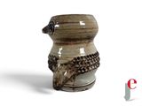 a brown and white vase that has a bird on it