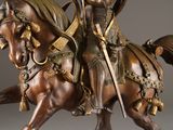 bronze statue of a man riding a horse with a sword