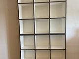 a tall bookcase in the corner of a room