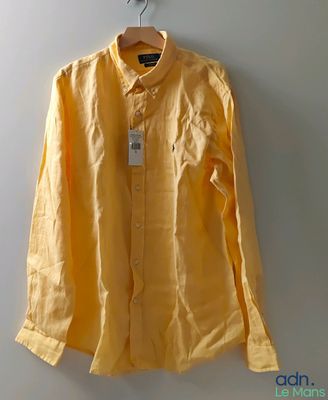 une chemise jaune suspendue à un cintre accroché au mur d'une pièce