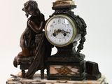 une statue représentant une femme assise sur un banc à côté d'une horloge