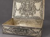 an antique silver box with a design on the lid