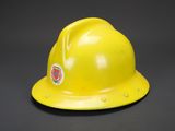 a close up of a yellow hard hat on a black background