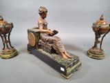 a statue of a woman sitting on a bench next to two other statues