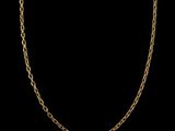a gold chain necklace with an oval link on a black background