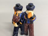 two figurines of two men sitting on a bench