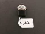 a silver ring with a diamond on it sitting on top of a black surface