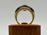 a close up of a gold ring on a wooden stand