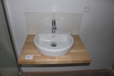 a white sink sitting on a wooden counter in a bathroom