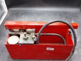 une boîte à outils rouge contenant un tuyau
