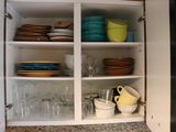 a cabinet with dishes and glasses in it