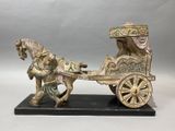 statue of a horse pulling a carriage with a man on it
