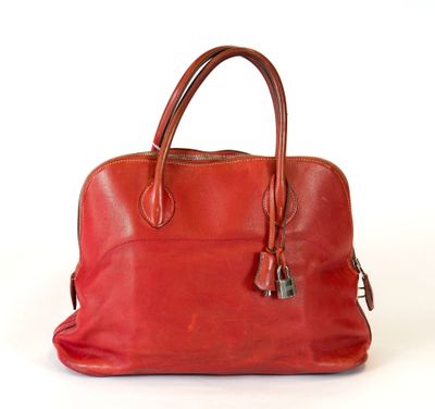 une image représentant un sac à main en cuir rouge sur fond blanc