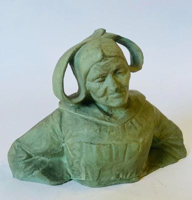 une statue verte représentant une femme coiffée d'un chapeau