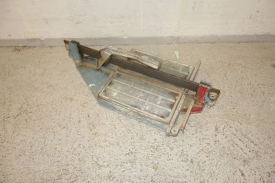 a small metal object on the floor next to a wall