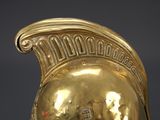 a gold helmet on display on a black surface