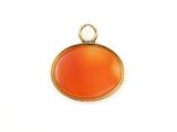un gros plan d'un pendentif orange sur une surface blanche