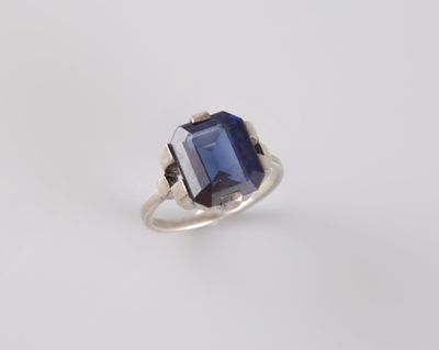une image représentant une bague sertie d'un saphir bleu sur fond blanc