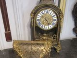 une horloge en or posée sur une table à côté d'un miroir