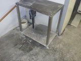 une table en métal sur laquelle est posé un seau, dans une pièce