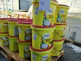 plusieurs seaux de peinture jaune sur une palette