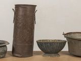 three vases and two bowls sitting on a table