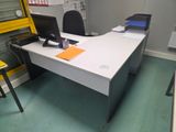un bureau avec un ordinateur et une chaise dans une pièce