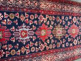 an oriental rug on the ground with a cat sitting next to it