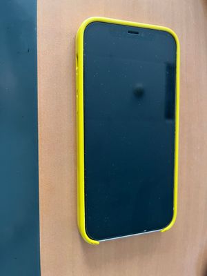 un téléphone portable noir et jaune accroché à un mur en bois