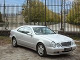 une voiture argentée garée devant une clôture