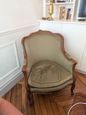 a chair in the corner of a room with a lamp on