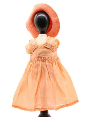 un mannequin vêtu d'une robe et coiffé d'un chapeau