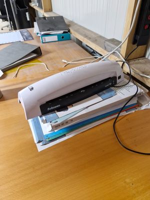 une agrafeuse posée sur une pile de papiers, sur un bureau