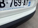 a close up of a white car with a license plate on it