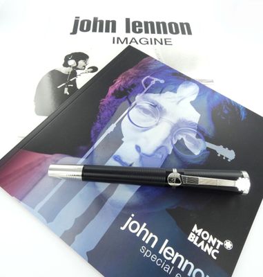a pen sitting on top of a book with a picture of john lennon on it