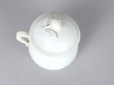 a close up of a white pot with a bird on it