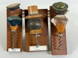 three wooden wine openers with hats on them
