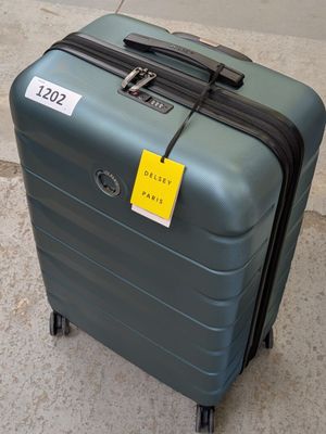 un bagage posé par terre, sur lequel est collé un autocollant