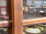 une vitrine sur laquelle sont posées des assiettes, devant une fenêtre