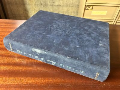 an old blue book sitting on top of a wooden table