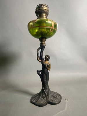 un vase vert posé sur un socle, tenu par une femme
