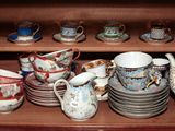 de nombreuses tasses et soucoupes posées sur une étagère dans un placard