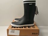 une photo d'une paire de bottes de pluie noires posées sur une boîte