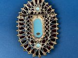 a close up of a broochle on a blue surface
